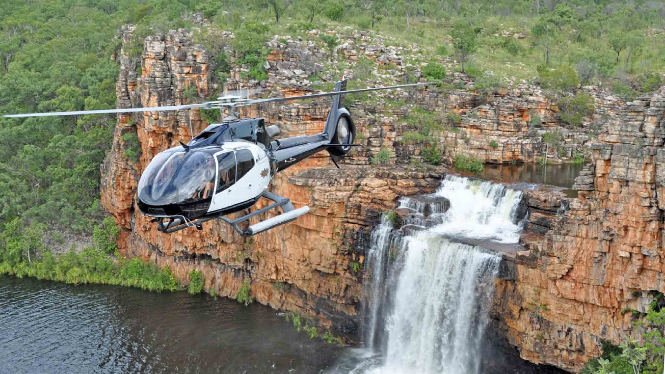 true-north-cruise-australia-papua-helicopter-flying-near-waterfall