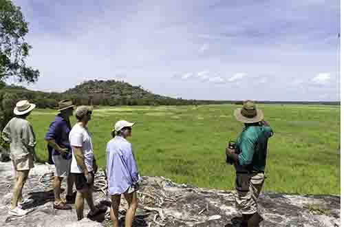 local-guide-showing-tourists-field