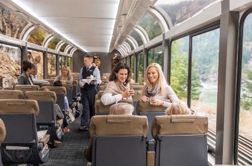 silverleaf-service-onboard-interior-canadian-rockies-canada-rocky-mountaineer-rail-guests-chatting-socialising-wine